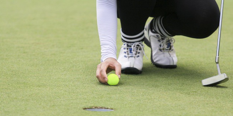 woman golf player putting green