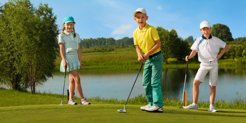 Trys vaikai žaidžia golfą su vaikiškomis plastikinėmis golfo lazdomis